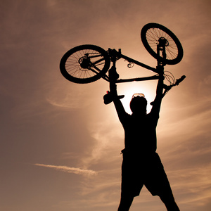 一个男人与自行车背景的轮廓。积极健康的户外生活方式的概念