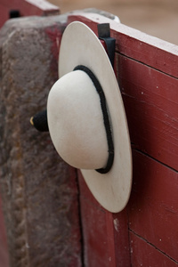 A castoreo the picadors rounded hat hanging from the barrier 