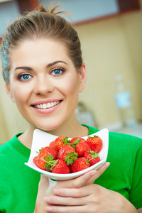 面带笑容的女人吃草莓