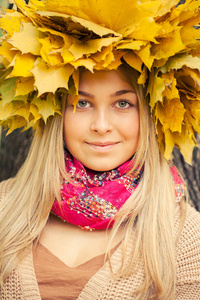 年轻女人穿着一个花圈秋天叶子
