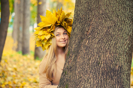 年轻女人穿着一个花圈秋天叶子