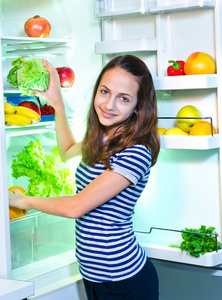 年轻漂亮的女孩附近冰箱用健康的食物