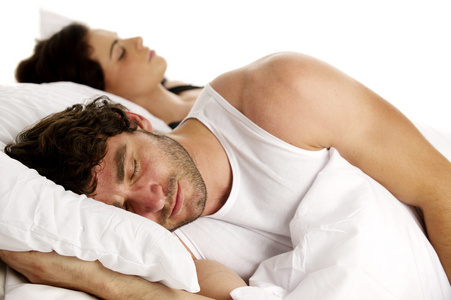 男子躺在白色的床旁边一名女子睡