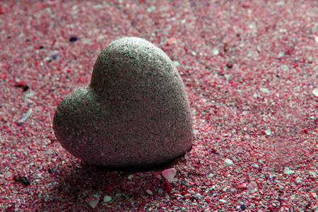 灰色的石头在心，砂背景上的形状