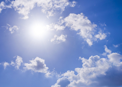 对洁白的云朵太阳对明亮的蓝色天空和洁白的云朵照片