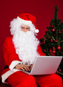使用笔记本电脑的圣诞老人