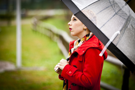 孤独的女孩在一个公园里一个下雨天用的伞