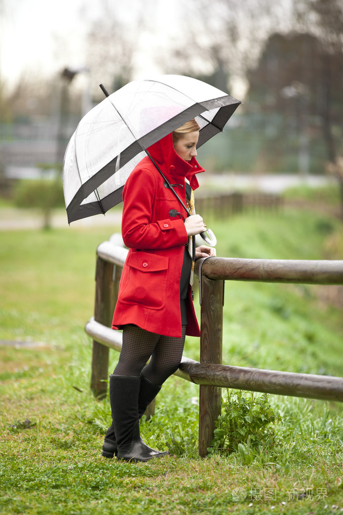 孤独的女孩在一个公园里一个下雨天用的伞