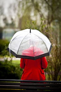 孤独的女孩在一个公园里一个下雨天用的伞