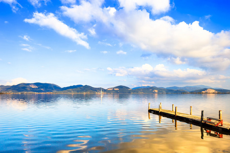 木码头和碧蓝的湖水日落和天空倒影。意大利的托斯卡纳，维西利亚