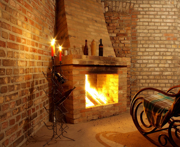 老式室内有壁炉和蜡烛的摇椅上照片