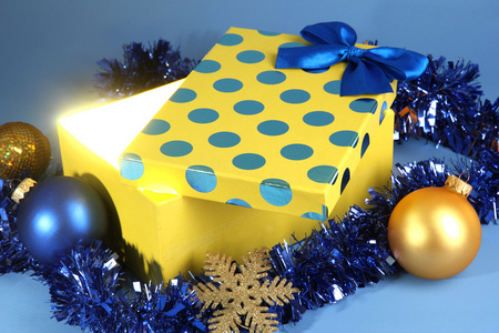 礼品盒与明亮的光，它在蓝色背景上