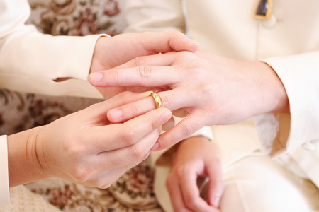 新娘对新郎的手指，把一枚结婚戒指关闭