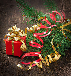 圣诞礼物和冷杉树枝上的旧的木制背景