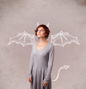 年轻女孩的恶魔之角和绘图的翅膀照片