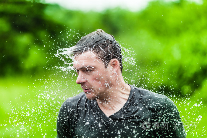 年轻的成年人完全湿透了摇了摇头