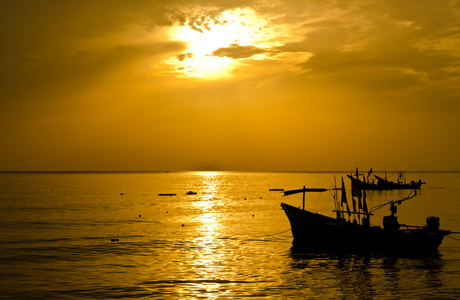 日出与渔民渔船剪影