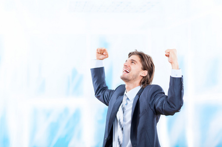 成功的兴奋业务男人幸福的微笑举行拳头了手势在明亮的蓝色办公室