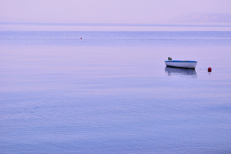 小寂寞渔船漂浮在平坦的表面的海洋上
