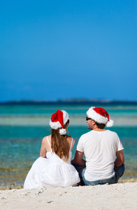 情侣在海滩上圣诞老人的帽子