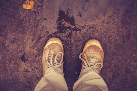 看他或她的鞋子，在泥地里的人