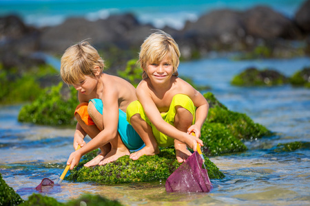 快乐的年轻孩子在暑假的时候在海滩玩