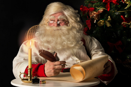 圣诞老人坐在家里和写作的待办事项列表