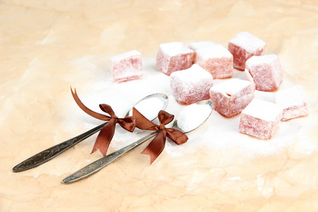 糖粉,棕色背景上的美味东方糖果 (土耳其软糖)照片