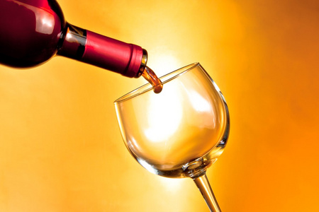 瓶的灌装在金色的背景上一杯红酒开始