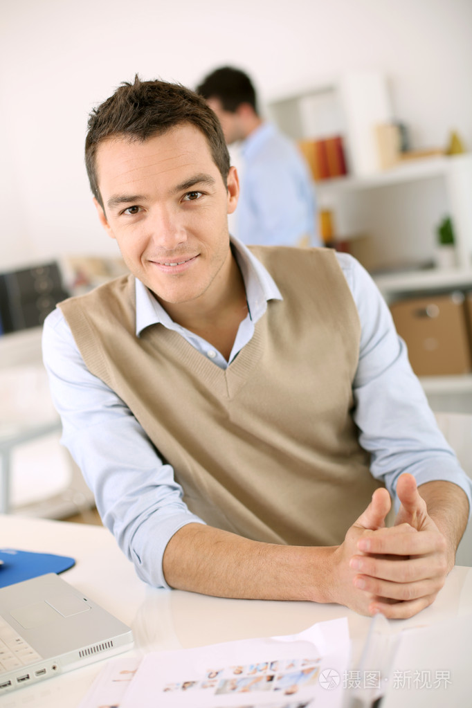 坐在办公室桌上的男人