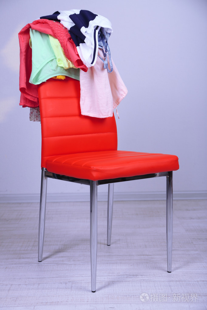 堆衣服在颜色的椅子上在灰色的背景上