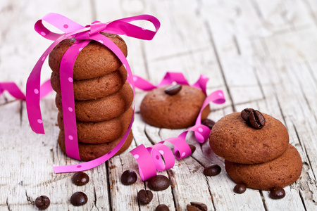 堆栈的巧克力曲奇饼，用粉红色的丝带和咖啡豆绑