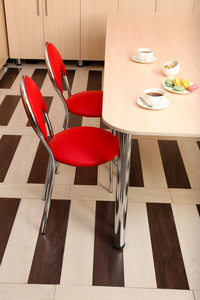 现代红色椅子在厨房的桌子旁边