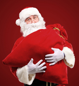 圣诞老人拥抱巨大红色礼品袋的肖像