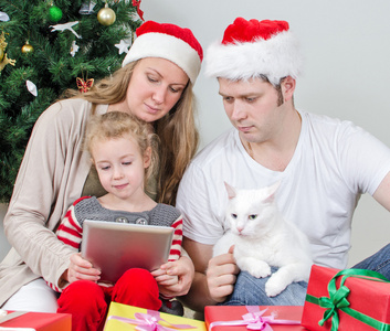 tablet pc 在圣诞树前的家庭