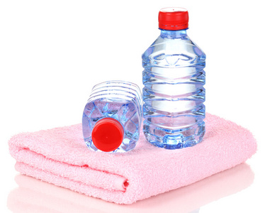 孤立在白色的毛巾上的水的塑料瓶