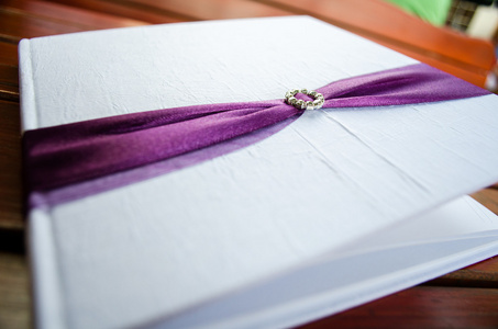 婚礼用紫色的丝带装饰留言簿图片