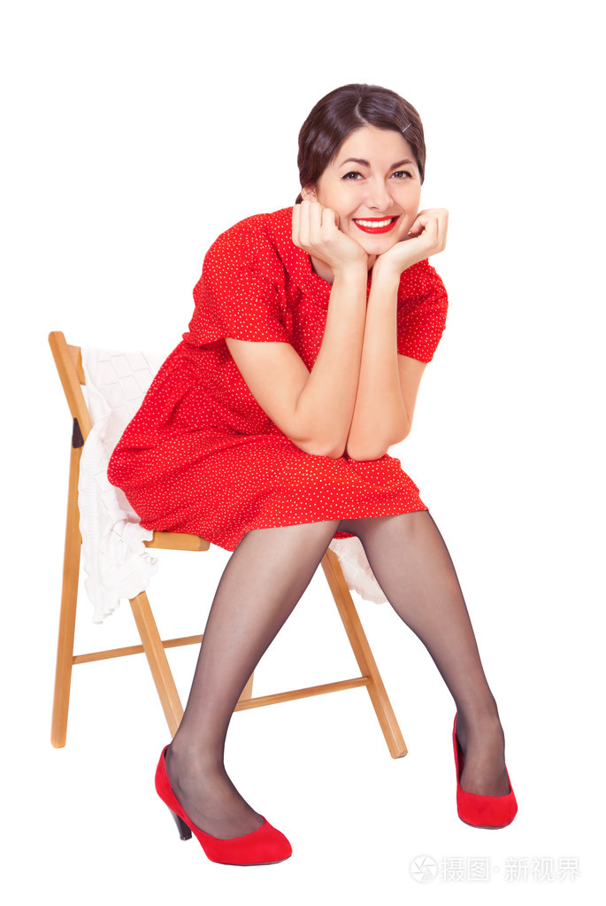 幸福的女人穿着红色的坐在椅子上