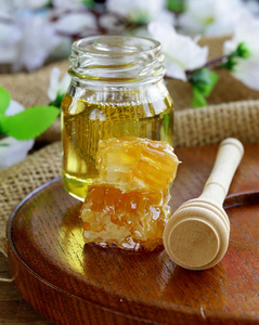 梳子和玻璃罐中的天然有机蜂蜜