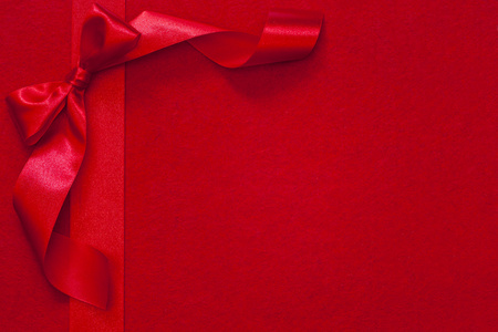 圣诞节带红色织物背景上的蝴蝶结照片