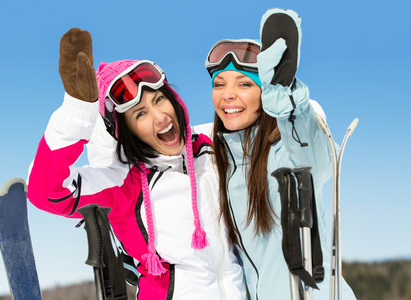 两个女滑雪者朋友举起手来