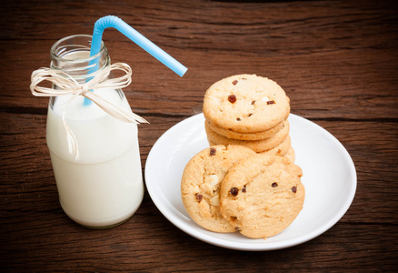 饼干和木桌上的瓶牛奶