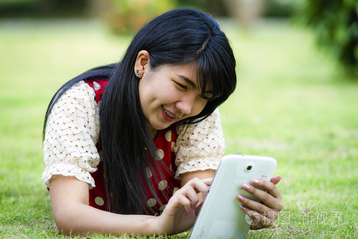 mujer de Asia usando tableta al aire libre使用平板电脑室外的亚洲女