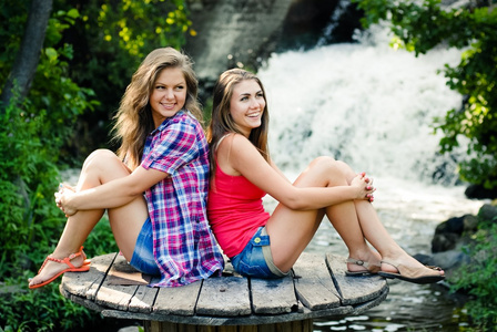 两个少女坐在瀑布
