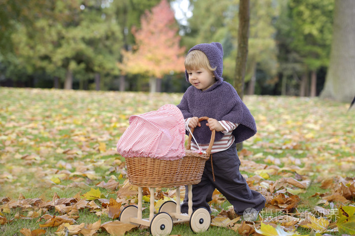 一辆婴儿车在公园里玩的小女孩