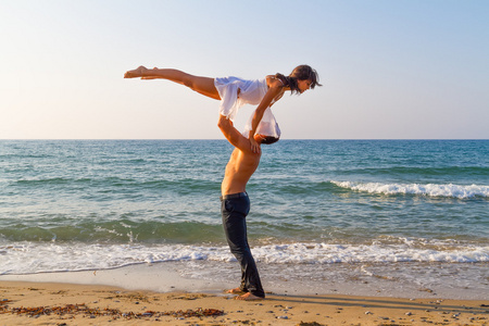 练习在海滩的舞蹈场景对年轻的夫妇