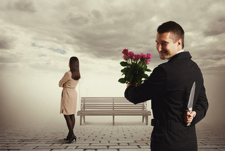 背信弃义的人用刀和鲜花照片