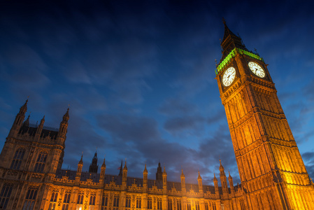 Lights big ben i skymningen med suddiga rrliga moln  london在黄昏