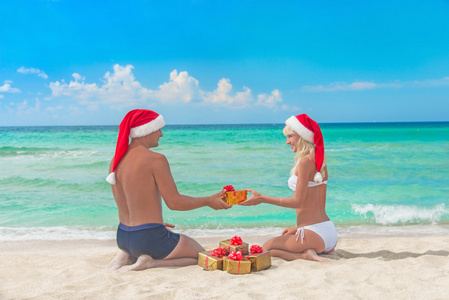 圣诞老人送礼物给他的女朋友在海面上的帽子的男人