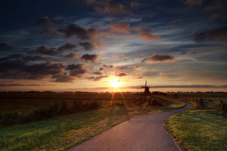 荷兰风车在农田上的夏季日出